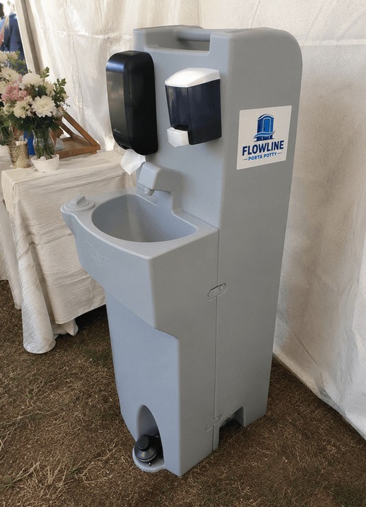 Portable handwash station with soap and paper towel dispensers inside an event tent