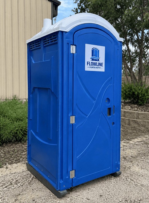 Single blue portable toilet placed beside a commercial building