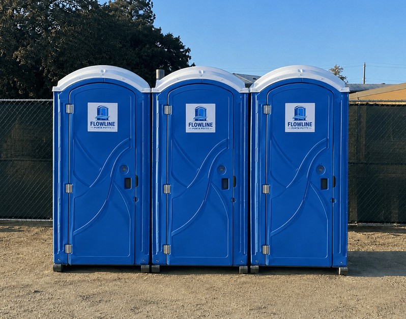 Blue standard porta potty units set out on gravel
